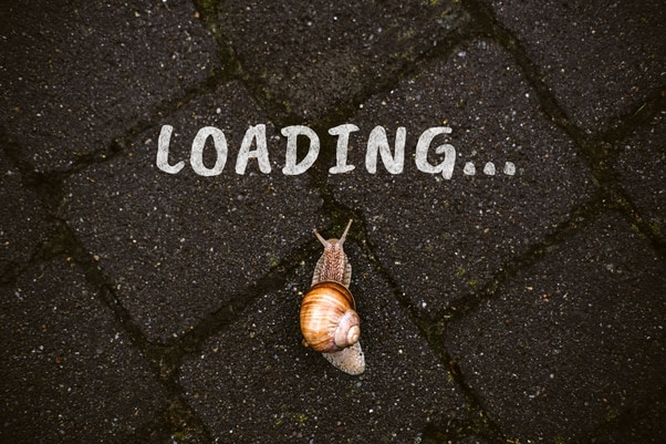 White text saying "Loading..." with snail below on black tiled background implying slow loading speed