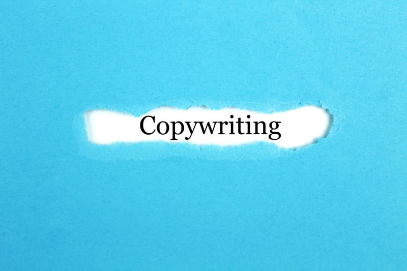 Torn blue paper with the word "Copywriting" revealed