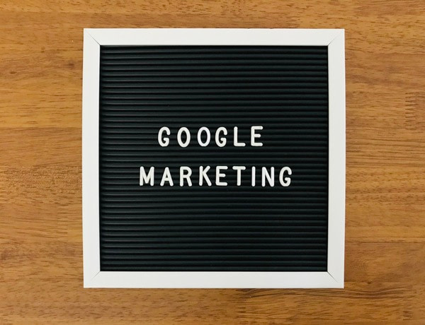 Google Marketing written in white on a blackboard, with a brown wooden background