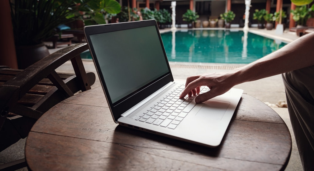 Buy Articles from Professional Content Writers banner. Guy sitting at fancy pool with laptop.